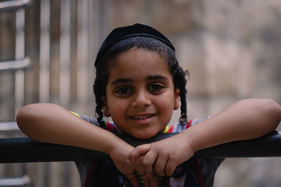A smiling boy with a kippah and peyot at the Western Wall